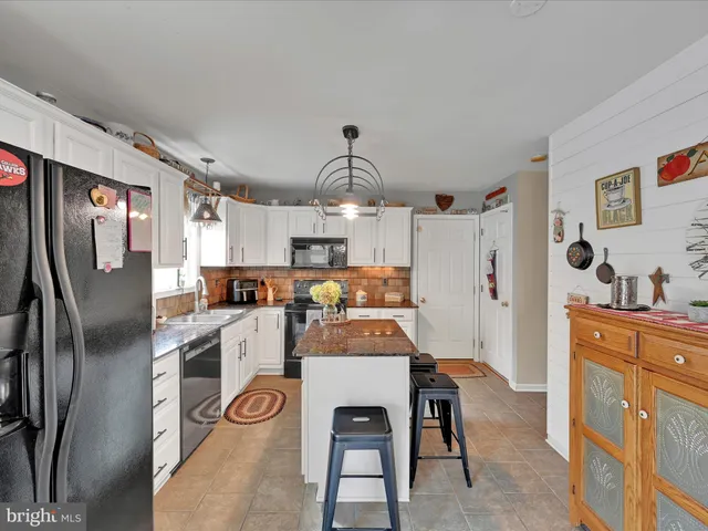 a kitchen with stainless steel appliances granite countertop a refrigerator and a stove top oven