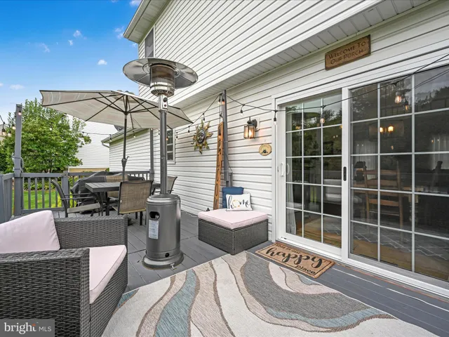 a view of a roof deck with couches chairs and wooden floor