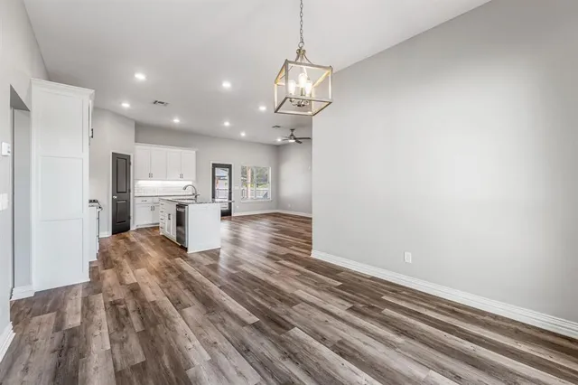 an empty room with a kitchen and windows