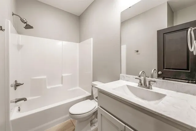 an empty room with chandelier fan and windows