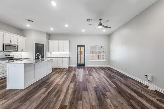 a view of kitchen with sink microwave refrigerator and cabinets