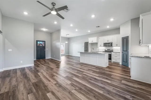 a kitchen with stainless steel appliances granite countertop a sink stove and refrigerator