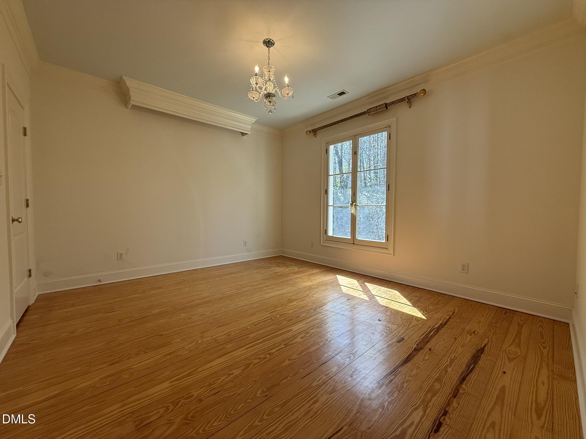 3617 Carlow Court Raleigh, NC 27612 - Photo 22 of 30 a view of an empty room with wooden floor and a window