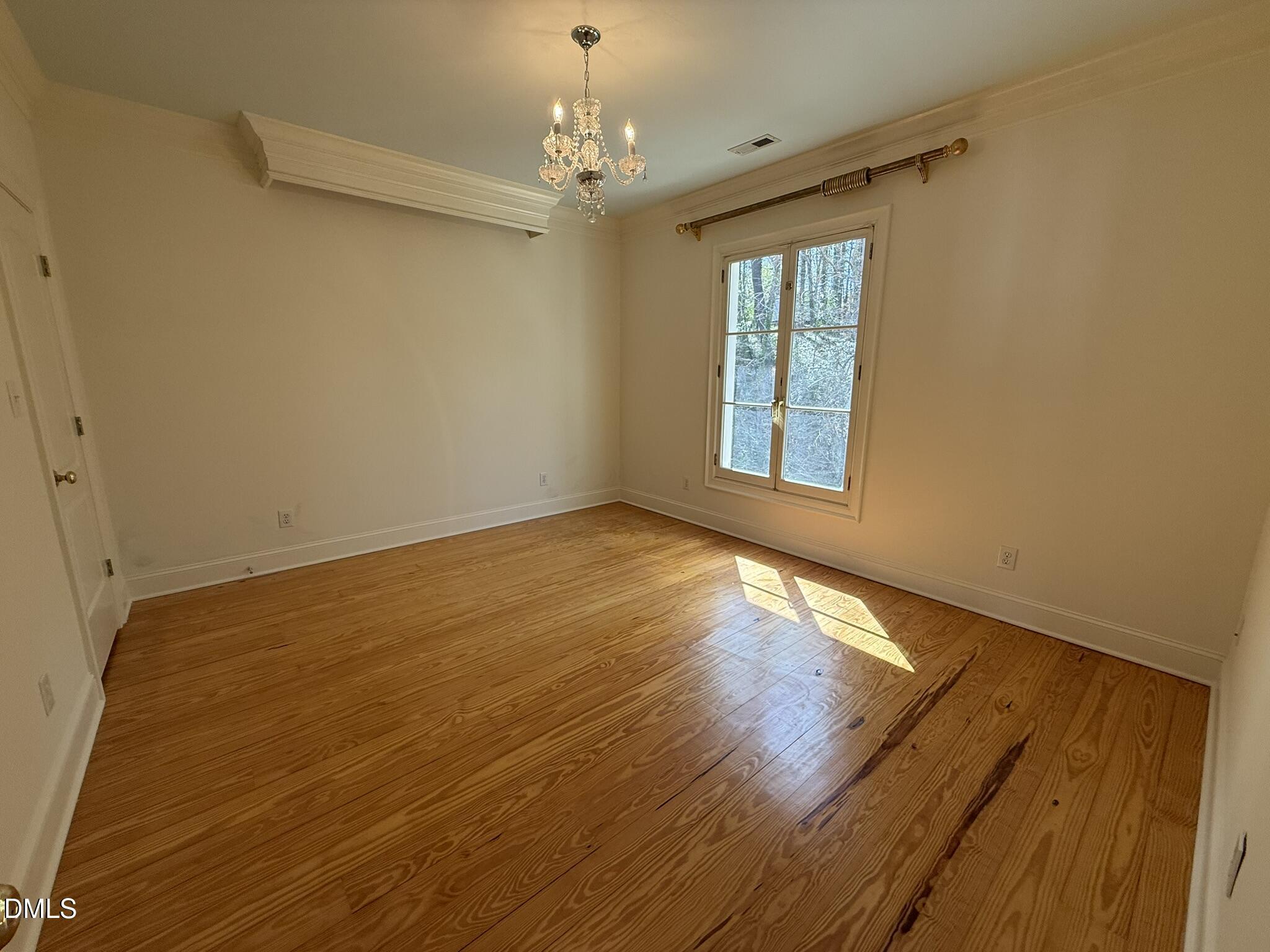 3617 Carlow Court Raleigh, NC 27612 - Photo 23 of 30 a view of an empty room with wooden floor and a window