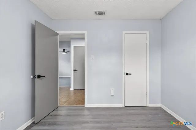 a view of an empty room with wooden floor