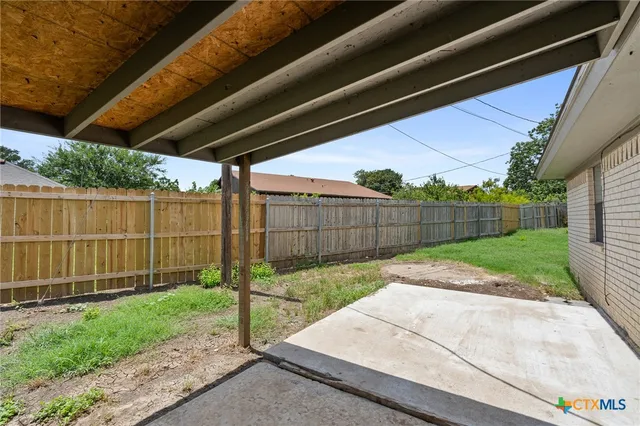 a view of a backyard with wooden fence