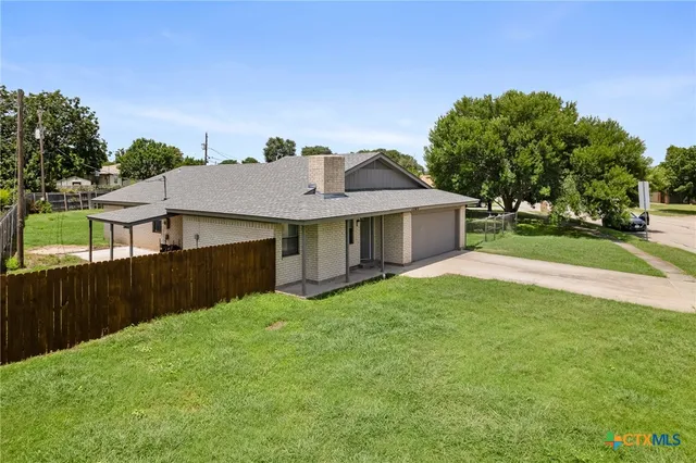 a view of a house with a yard and sitting area