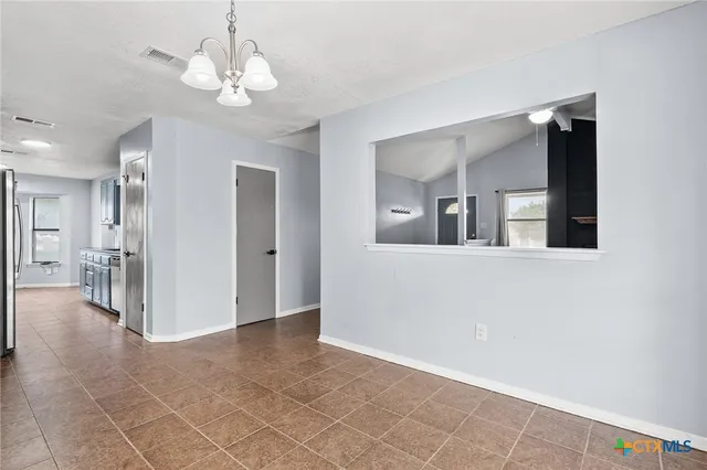 a view of a hallway with wooden floor and chandelier