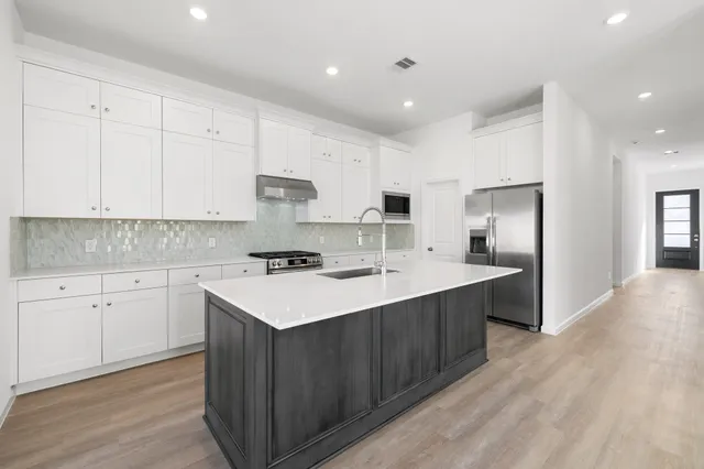 a kitchen with a sink stainless steel appliances and white cabinets