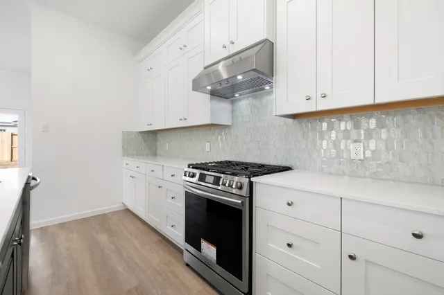 a kitchen with white cabinets and a stove