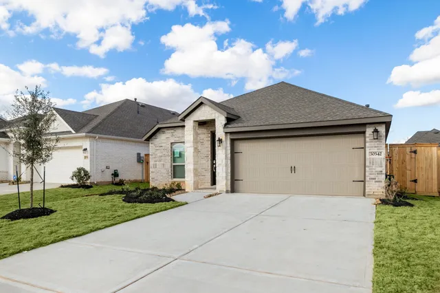 a front view of a house with a garden and trees