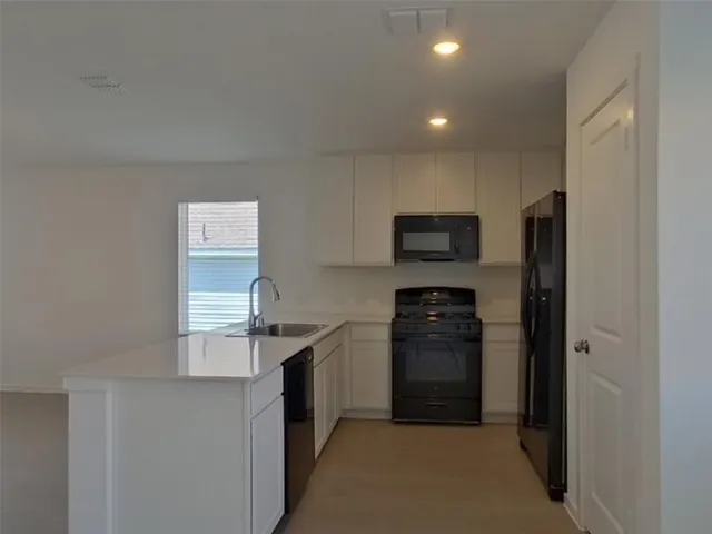 a kitchen with stainless steel appliances granite countertop a refrigerator and a stove