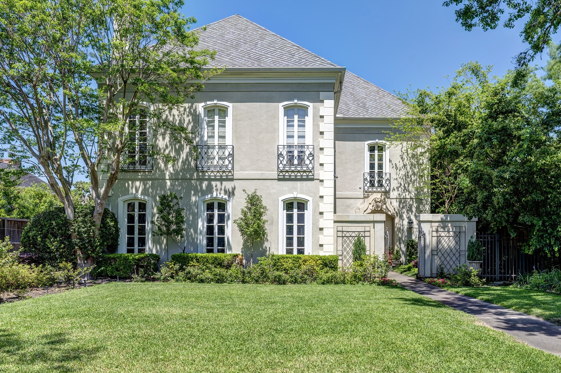 a front view of a house with a garden and plants