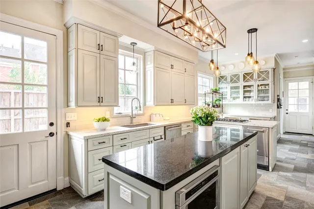 a kitchen with granite countertop a sink a stove and cabinets