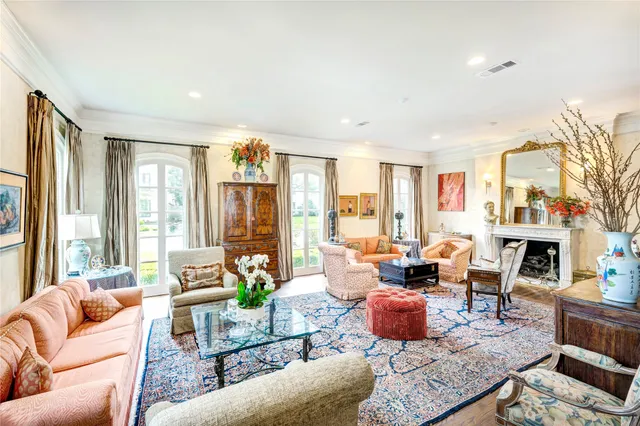 a living room with furniture large windows and a fireplace