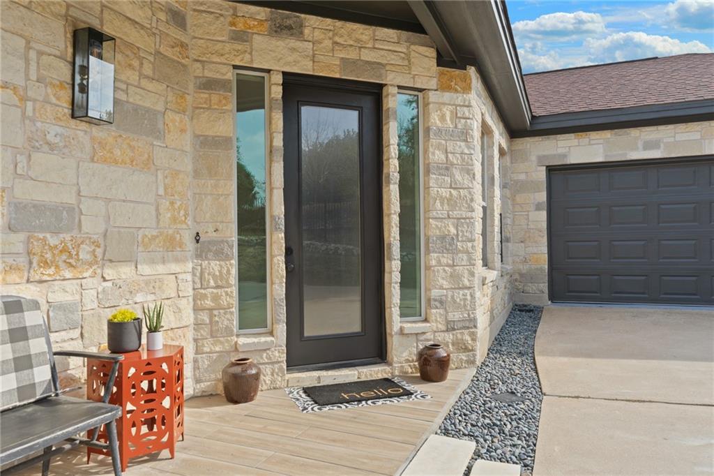 13301 Lone Rider Trail Bee Cave, TX 78738 - Photo 7 of 22 A welcoming stone facade and a modern front door create appealing curb appeal.