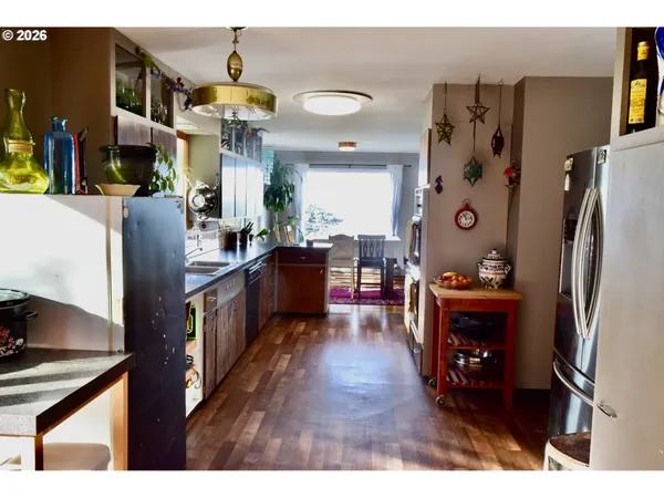 a living room with stainless steel appliances kitchen island granite countertop furniture and a refrigerator