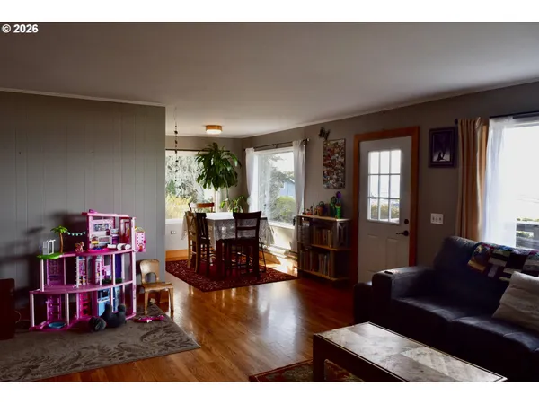a living room with furniture and a wooden floor