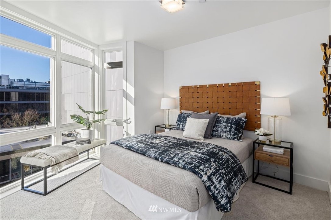 159 Denny Way, Unit 313 Seattle, WA 98109 - Photo 15 of 32 a bedroom with a large bed and a couch
