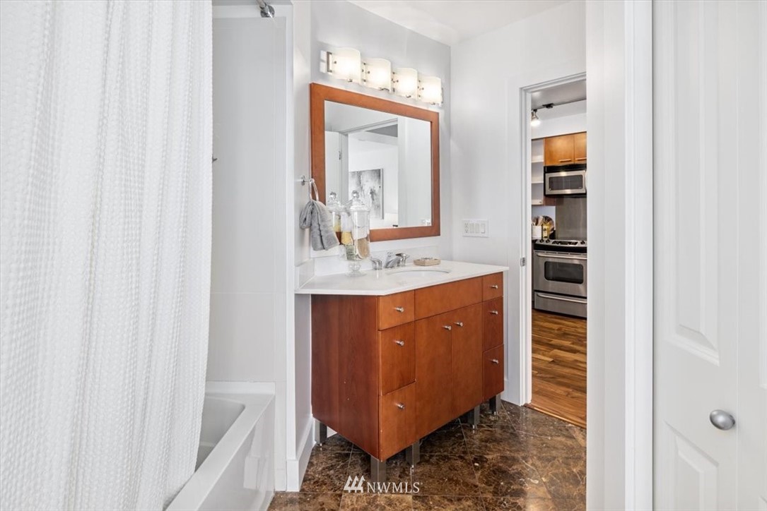 159 Denny Way, Unit 313 Seattle, WA 98109 - Photo 19 of 32 a bathroom with a sink and a mirror