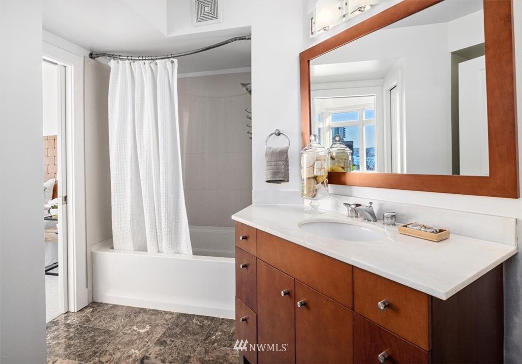 159 Denny Way, Unit 313 Seattle, WA 98109 - Photo 20 of 32 a bathroom with a sink vanity granite tub and a mirror