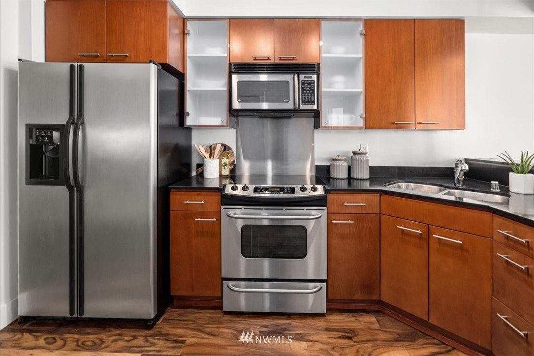 159 Denny Way, Unit 313 Seattle, WA 98109 - Photo 21 of 32 a kitchen with stainless steel appliances granite countertop a refrigerator a stove a sink and dishwasher