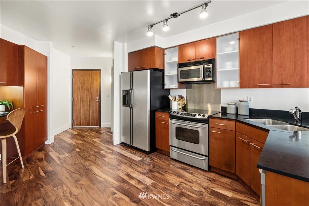 159 Denny Way, Unit 313 Seattle, WA 98109 - Photo 6 of 32 a kitchen with stainless steel appliances granite countertop a refrigerator stove and sink