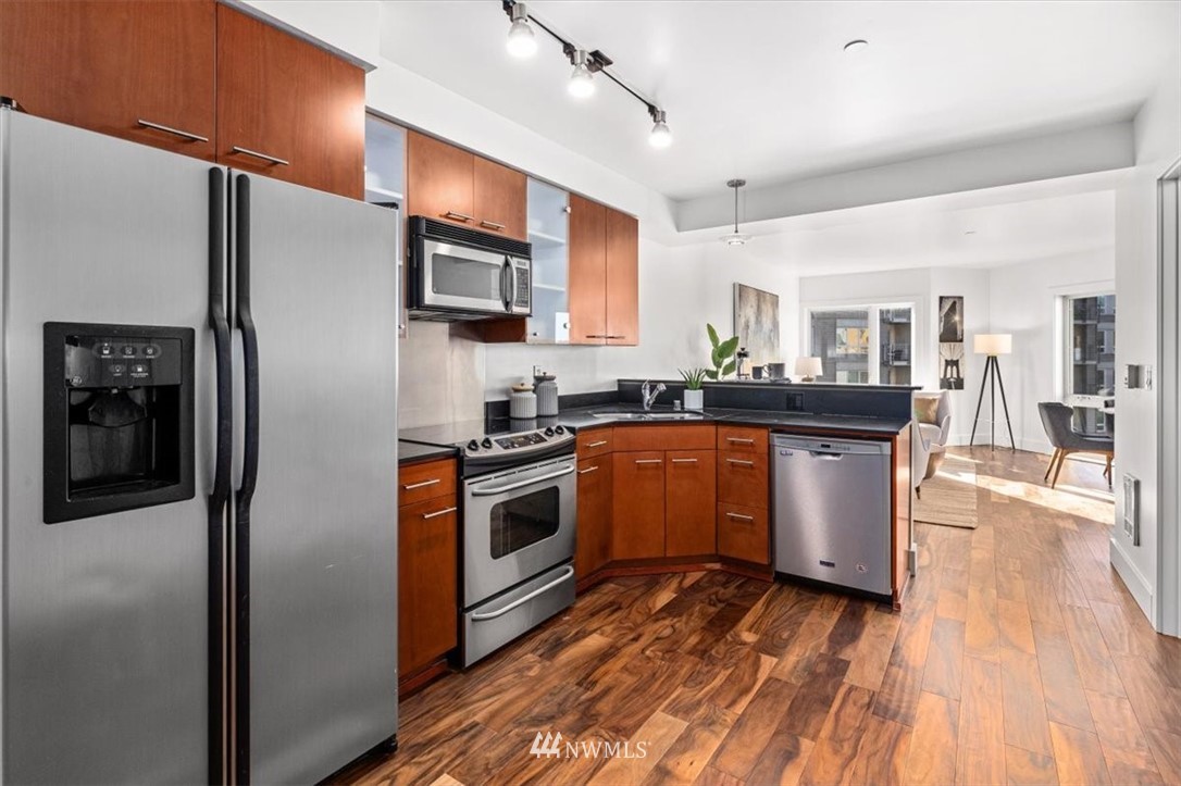 159 Denny Way, Unit 313 Seattle, WA 98109 - Photo 7 of 32 a kitchen with stainless steel appliances granite countertop a refrigerator a stove top oven a sink and dishwasher