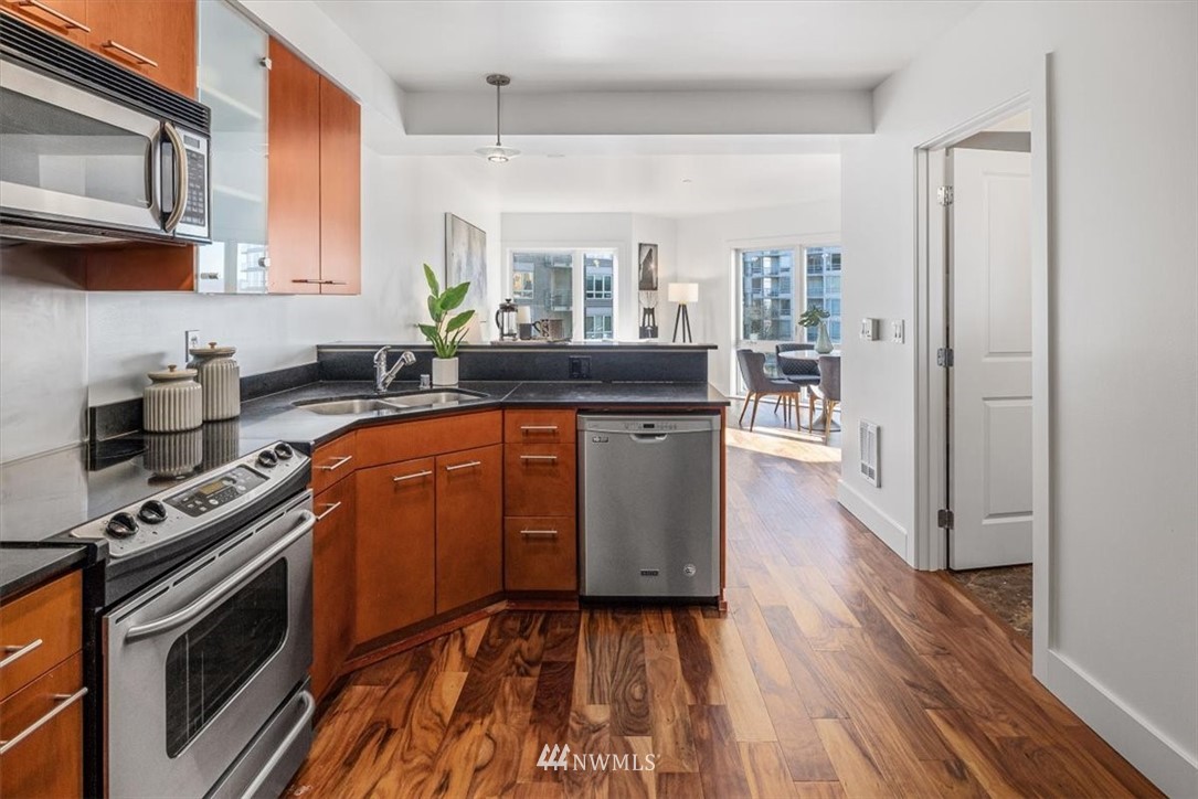 159 Denny Way, Unit 313 Seattle, WA 98109 - Photo 8 of 32 a kitchen with stainless steel appliances granite countertop a stove a sink and a microwave