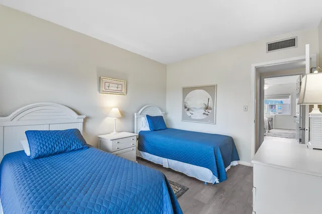 a bedroom with two beds and a large window