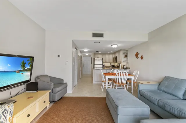 a living room with furniture and a dining table with kitchen view