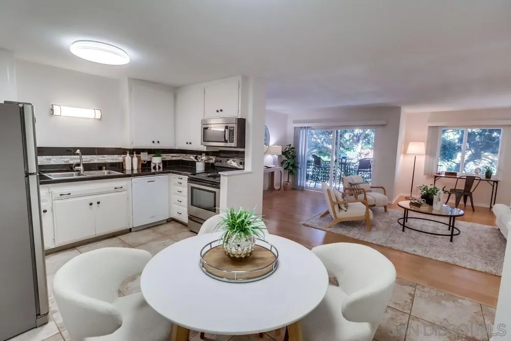 2244 2nd Avenue, Unit 25 San Diego, CA 92101 - Photo 11 of 27 a kitchen with stainless steel appliances kitchen island granite countertop a sink a stove a dining table and chairs