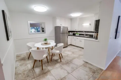 a kitchen with stainless steel appliances a table and chairs