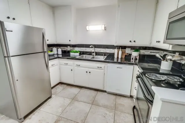 a kitchen with stainless steel appliances a refrigerator sink and cabinets