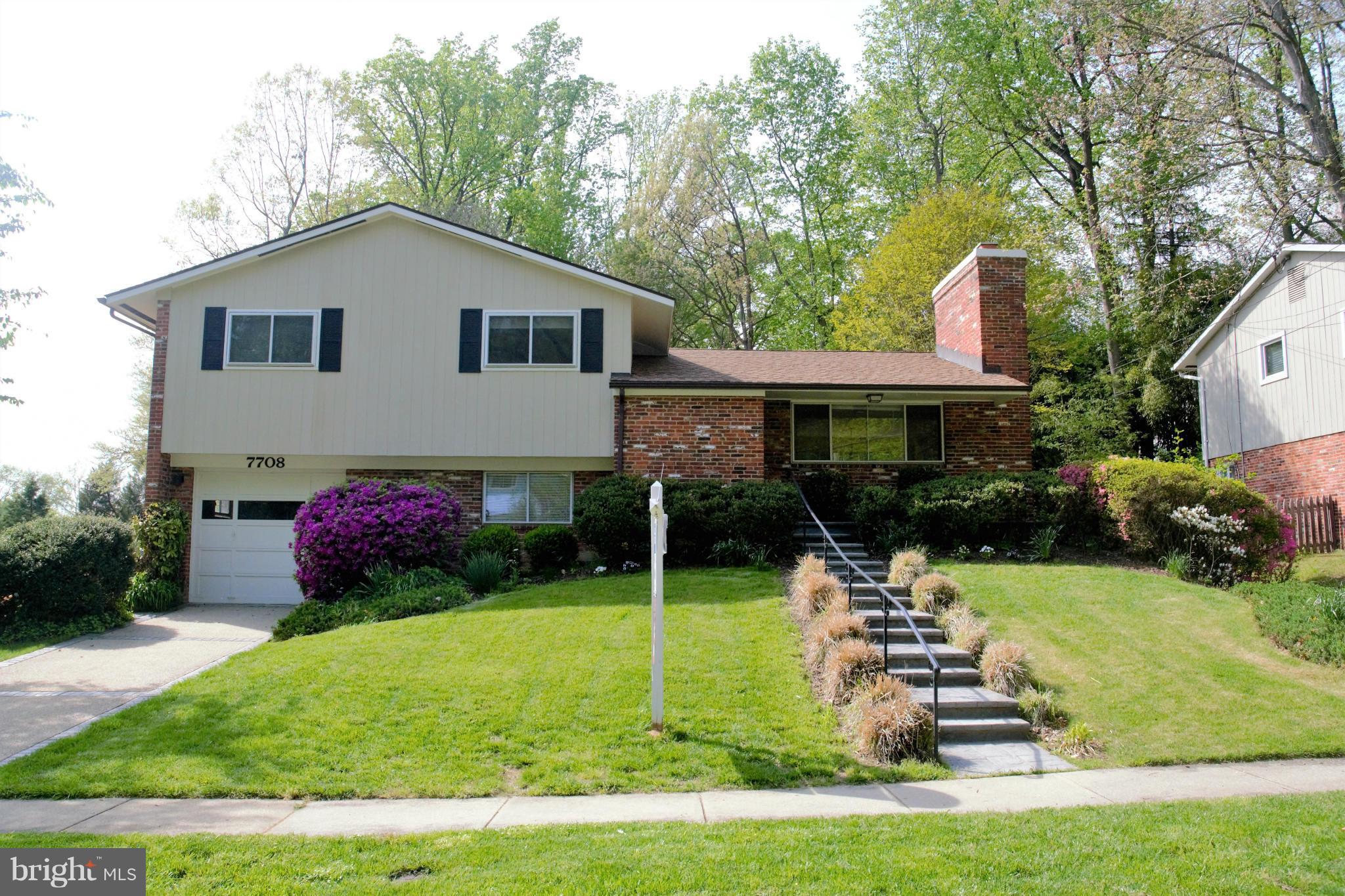 a view of house with a yard and potted plants