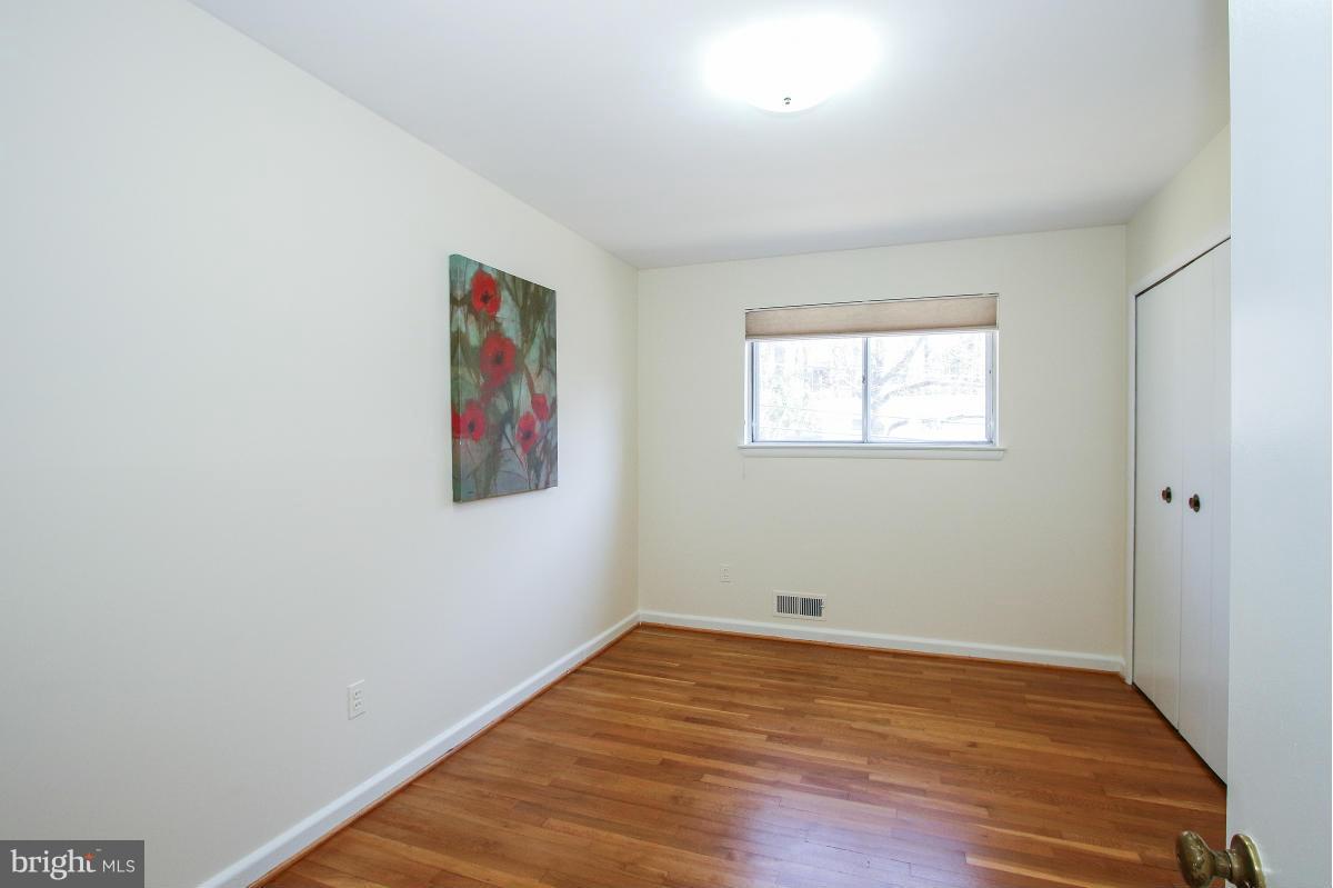 7708 Beech Tree Road Bethesda, MD 20817 - Photo 13 of 30 an empty room with wooden floor and windows