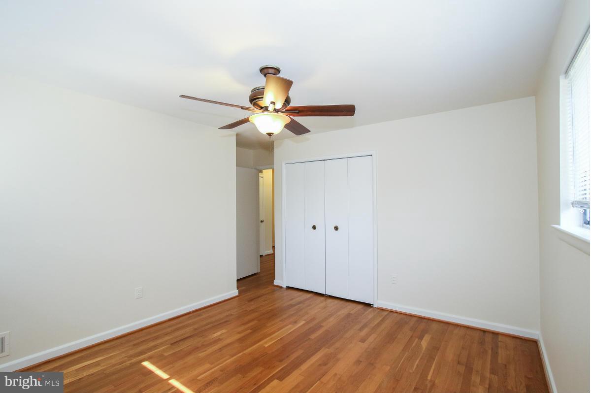 7708 Beech Tree Road Bethesda, MD 20817 - Photo 15 of 30 a view of a room with wooden floor and a ceiling fan