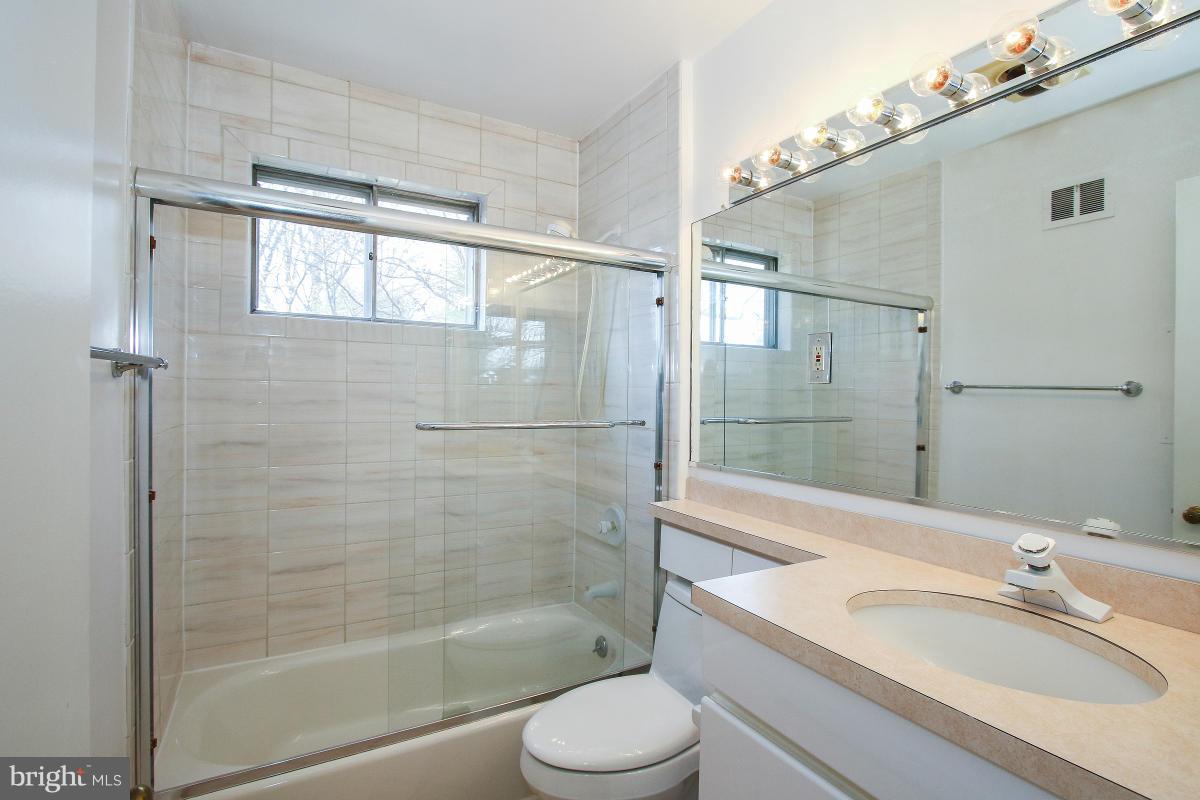 7708 Beech Tree Road Bethesda, MD 20817 - Photo 19 of 30 a bathroom with a granite countertop sink toilet and shower