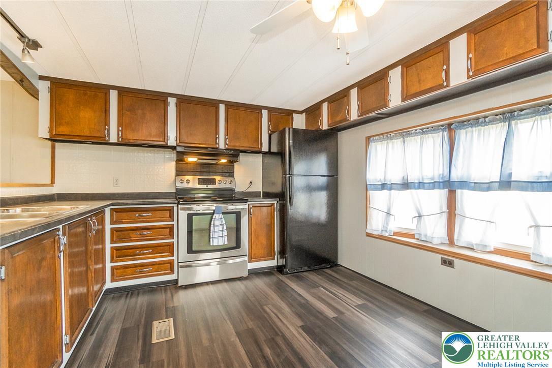 8721 Turkey Ridge Road Breinigsville, PA 18031 - Photo 10 of 30 Rich wood cabinetry and wood-look flooring define this functional kitchen space.