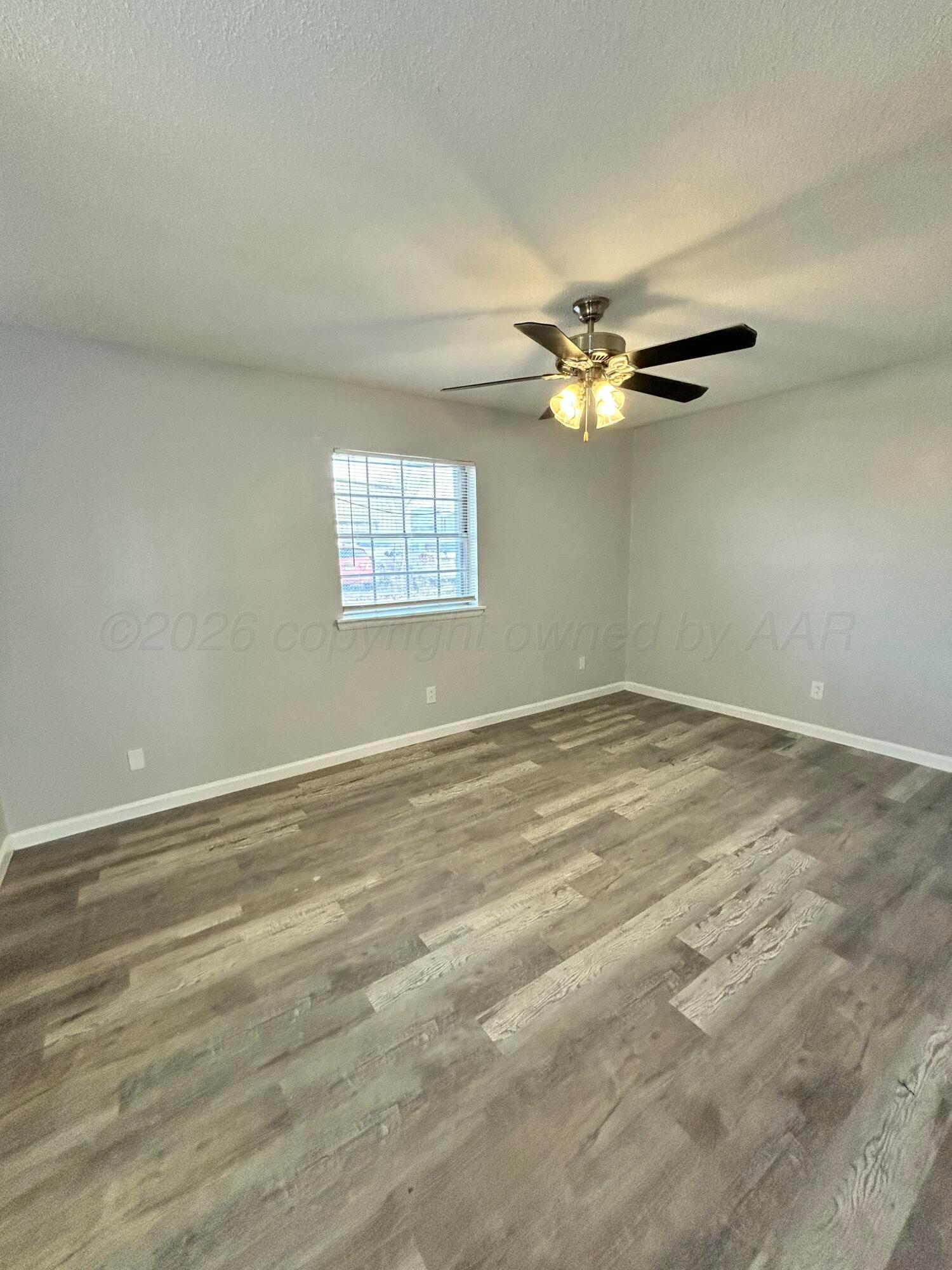 3020 Southwest 27th Avenue Amarillo, TX 79109 - Photo 11 of 18 an empty room with windows and ceiling fan view