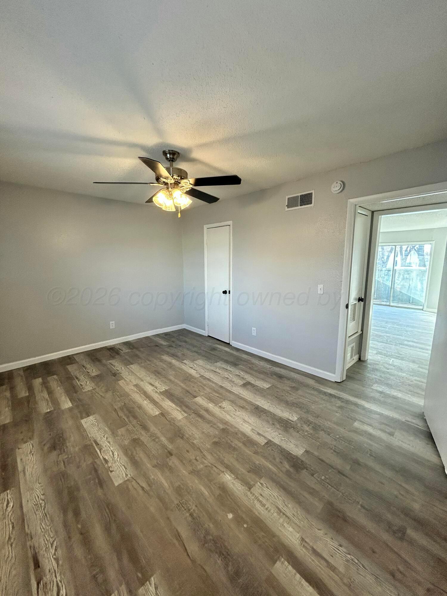 3020 Southwest 27th Avenue Amarillo, TX 79109 - Photo 15 of 18 an empty room with wooden floor and fan