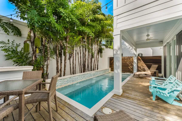 a view of a chairs and table in the back yard of the house