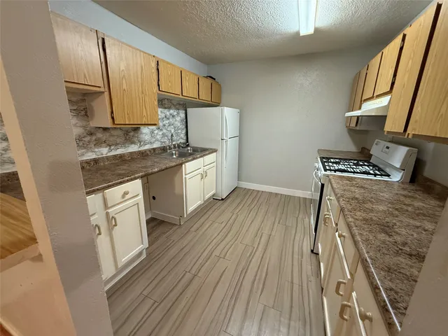 a kitchen with wooden floor and a stove top oven