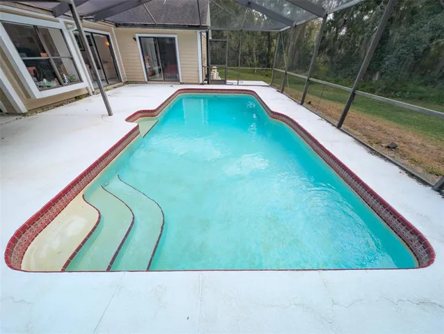 a yellow house with a big yard and large trees