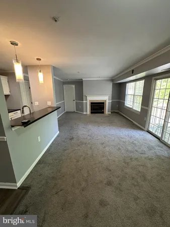an empty room with windows and fireplace