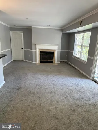 an empty room with windows and fireplace