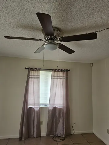 a view of a hallway to a room with a window and a flat screen tv