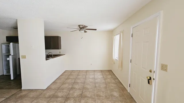a kitchen with a sink a refrigerator and cabinets