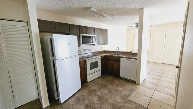a kitchen with granite countertop a sink and a microwave