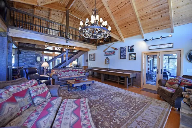 a kitchen with stainless steel appliances kitchen island granite countertop a refrigerator a sink dishwasher a stove with wooden cabinets and floor